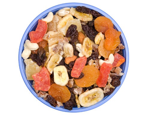 A bowl of trail mix isolated on a white background.