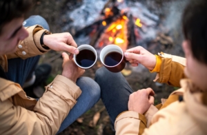 drinking coffee by a campfire